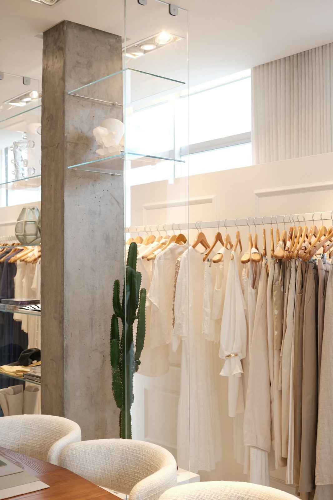 Dãy đầm và áo linen trắng treo trên móc gỗ trong cửa hàng