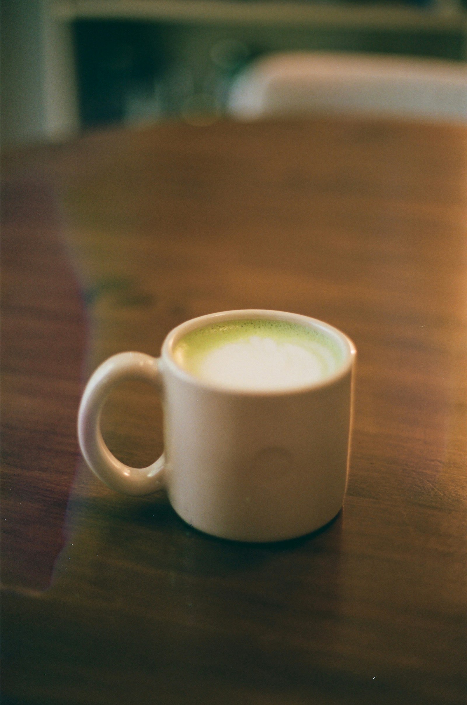 Ly matcha latte đặt trên bàn gỗ trong quán Mộc Matcha