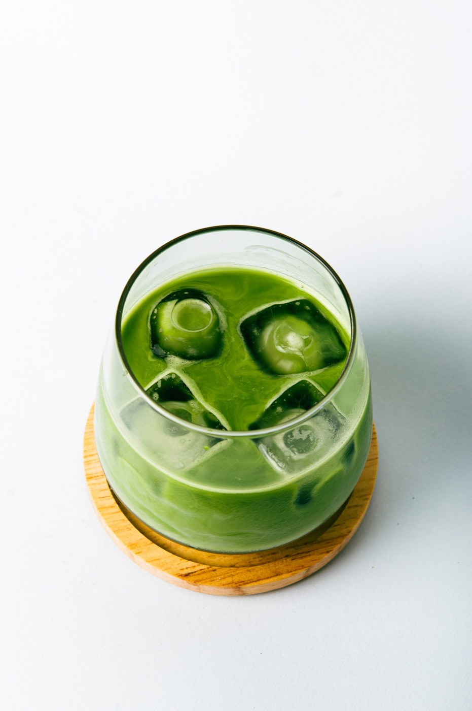 Ly matcha đá xay xanh mát với đá viên trên đế gỗ