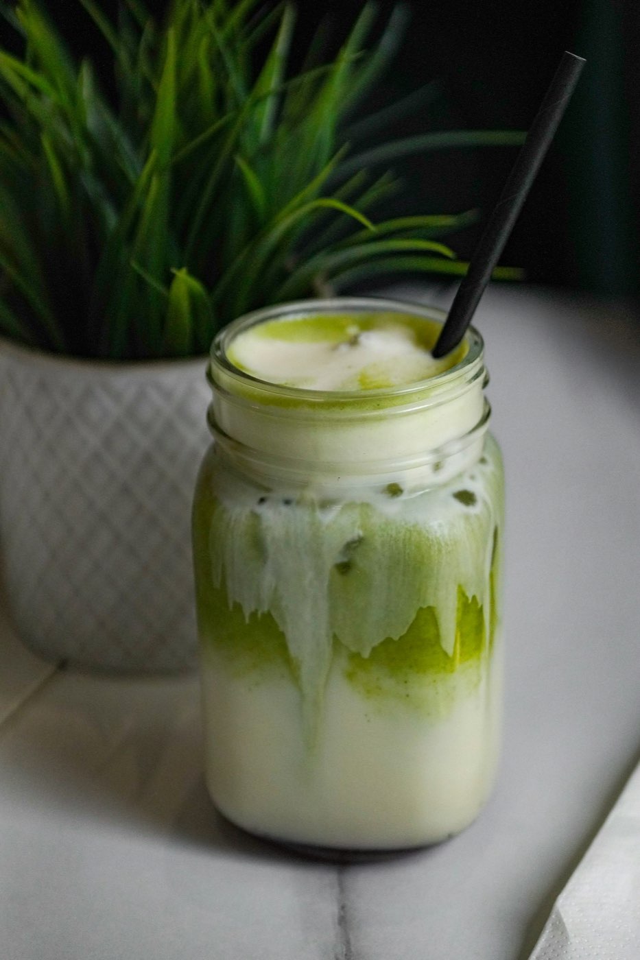 Matcha latte đá trong ly thuỷ tinh với ống hút giấy