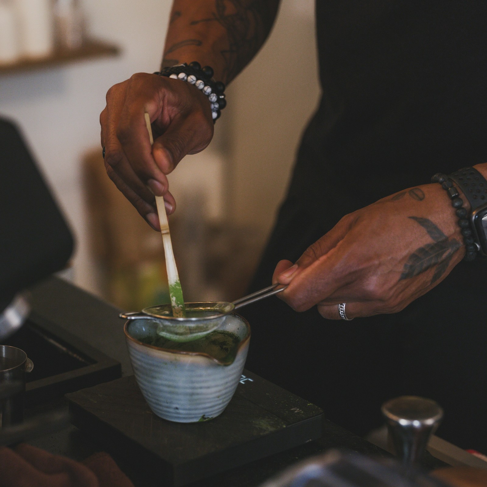 Barista lọc bột matcha tại quầy pha chế