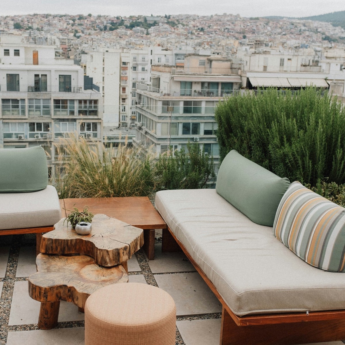 Sân vườn lounge trên cao với sofa gỗ nhìn ra thành phố